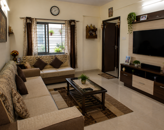 Contemporary Indian Family Living Room with Warm Walnut Entertainment Wall, Cozy Patterned Sofa Seating, Elegant Neutral Interiors, and Functional Everyday Comfort Design